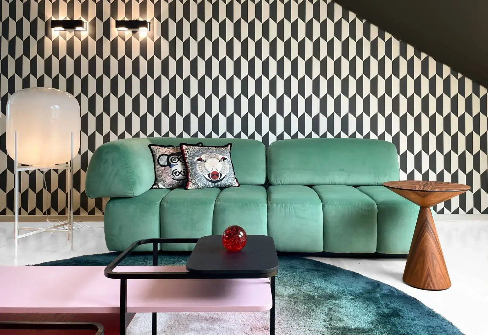 Showroom in Flieden mit mintgrünem Sofa vor grafischer Tapete, Couchtisch und runder Leuchte
